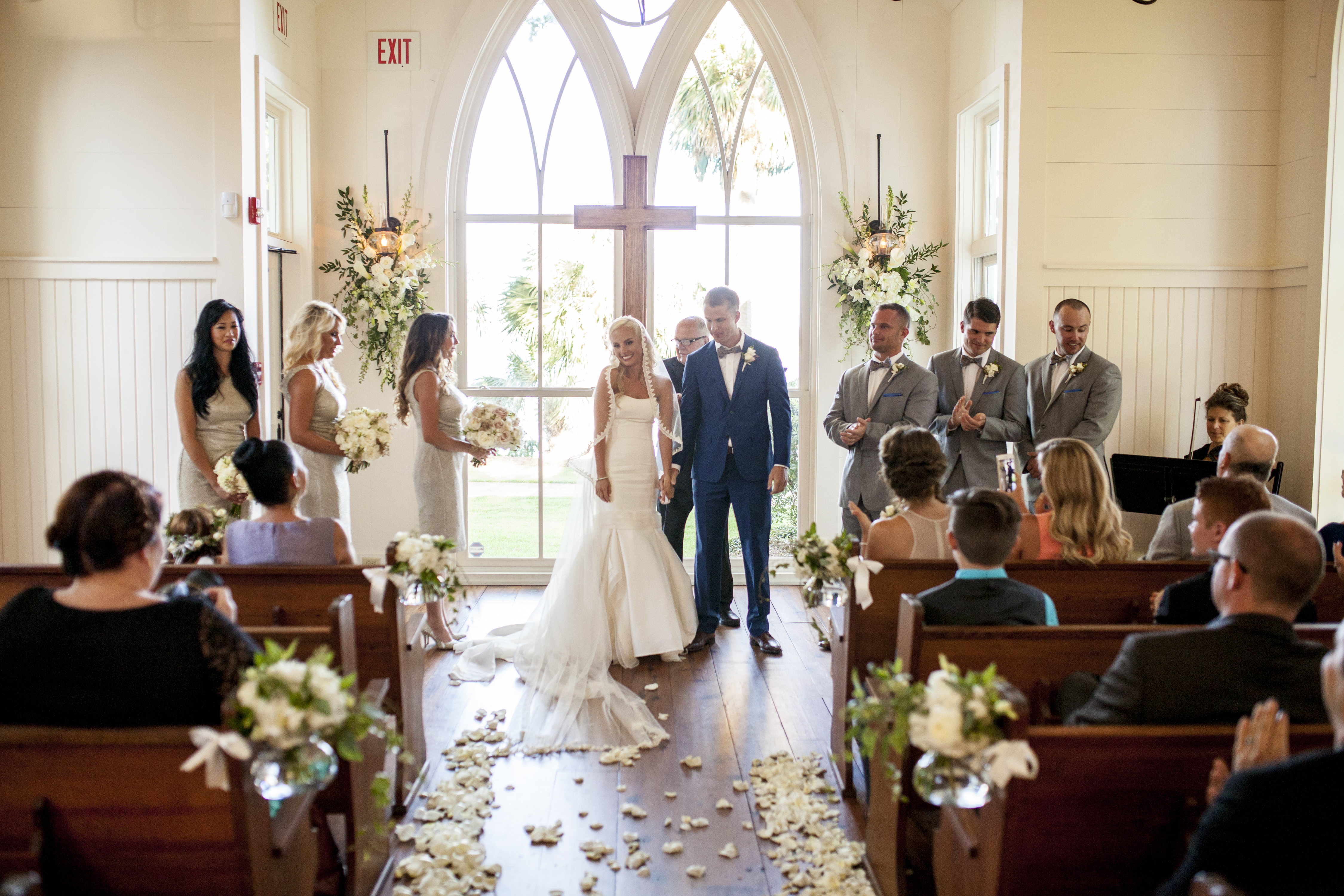 Elegant wedding ceremony arch decorated with soft, natural coastal florals